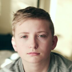 Mladý kluk, co se dívá přímo do objektivu